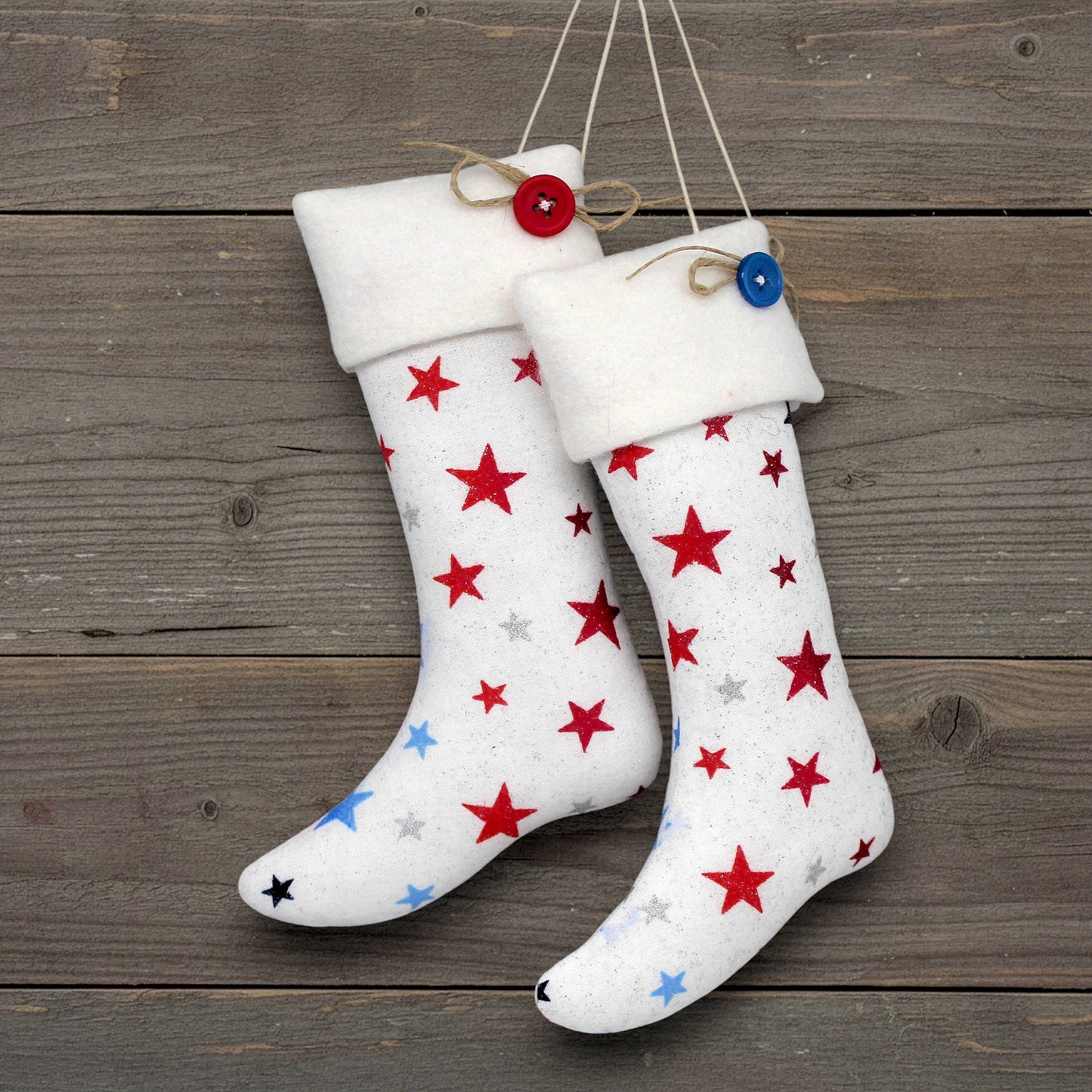 Pair of Christmas stocking ornaments with red and blue stars on a white background