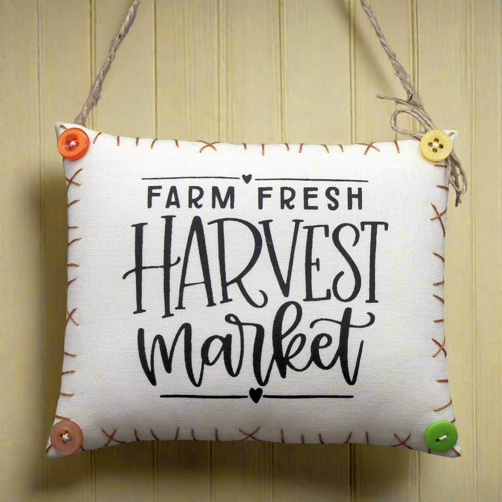 Decorative sign with 'Farm Fresh Harvest Market' text on a wooden background