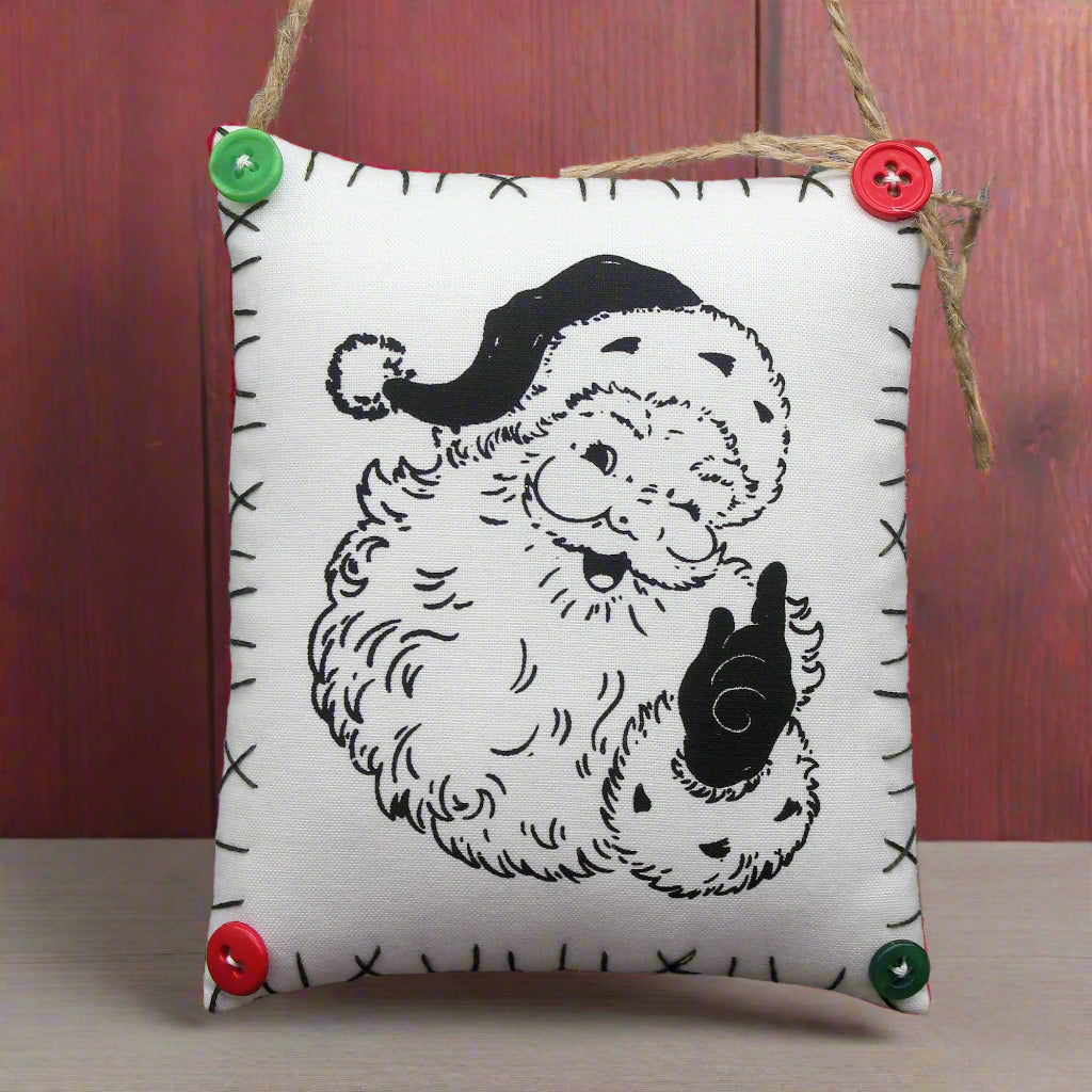 Hanging mini pillow sign with an image of a smiling Santa Claus