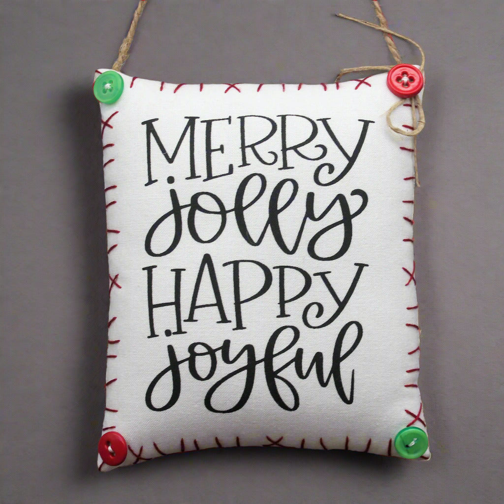 hanging mini pillow which reads Merry Jolly Happy Joyful
