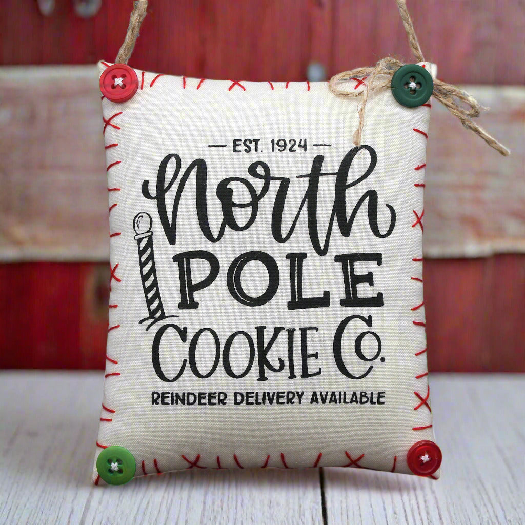 Hanging mini pillow sign ornament with 'North Pole Cookie Co.' text
