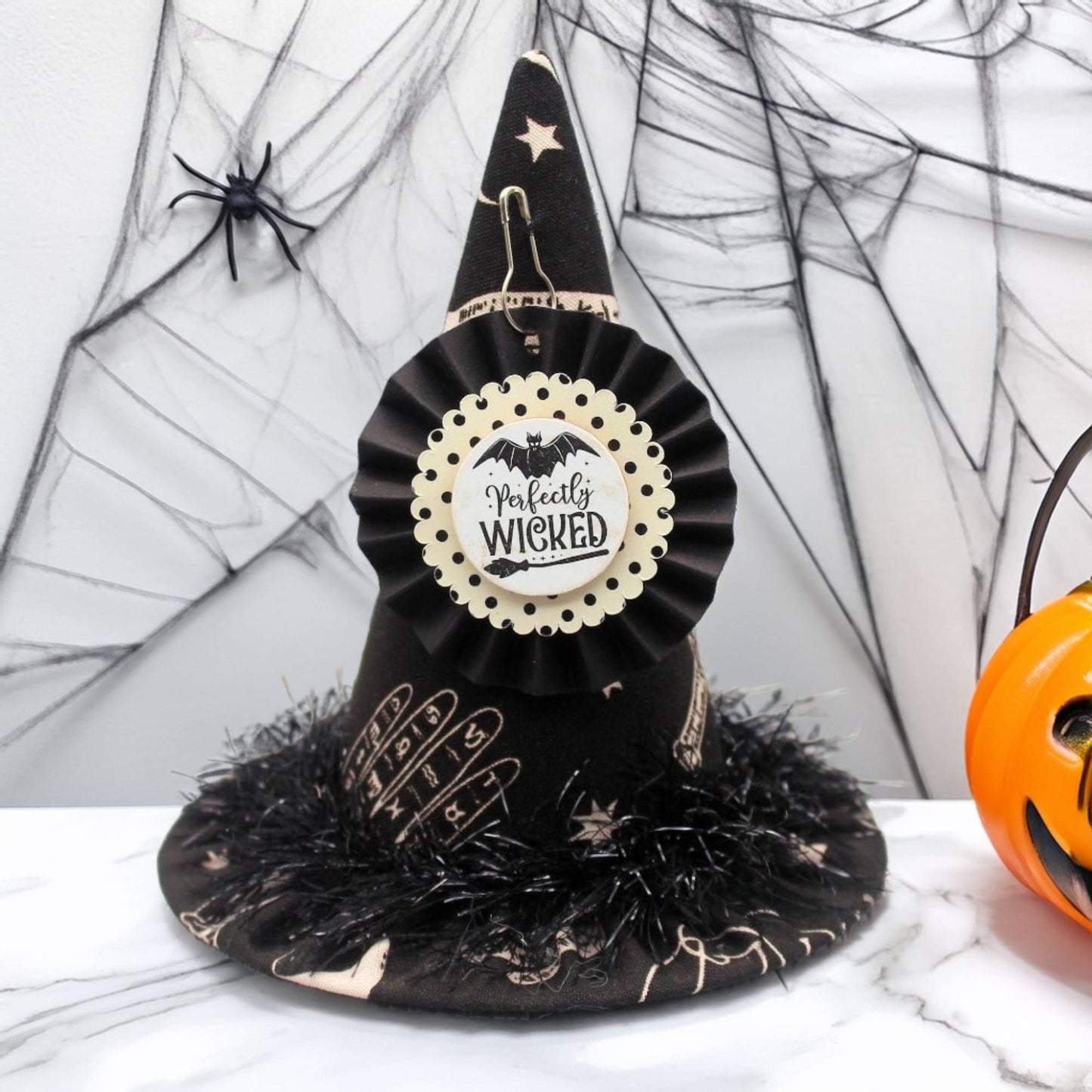 Black witch hat with decorative elements on a wooden surface