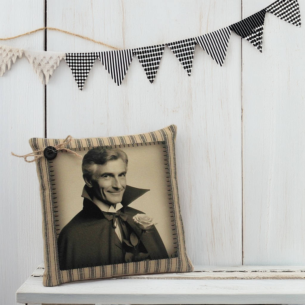 Decorative pillow with a vintage-style portrait on a wooden surface with a banner in the background.