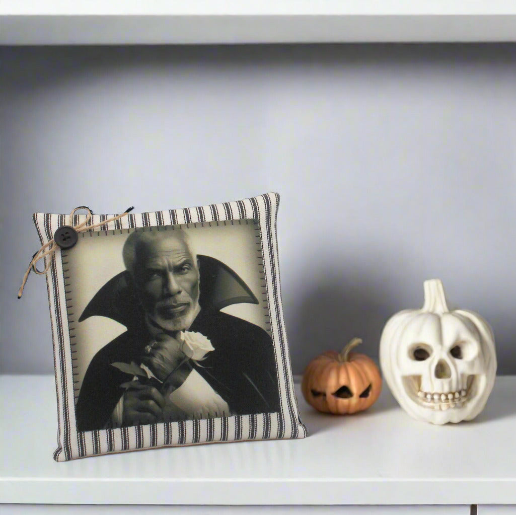 Decorative pillow with a black and white portrait of a handsome vampire holding a flower on a light gray background.