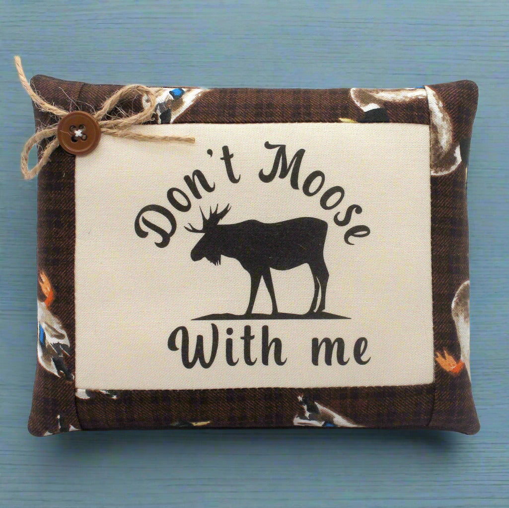 Small pillow tuck with 'Don't Moose With Me' text and moose silhouette on a blue background
