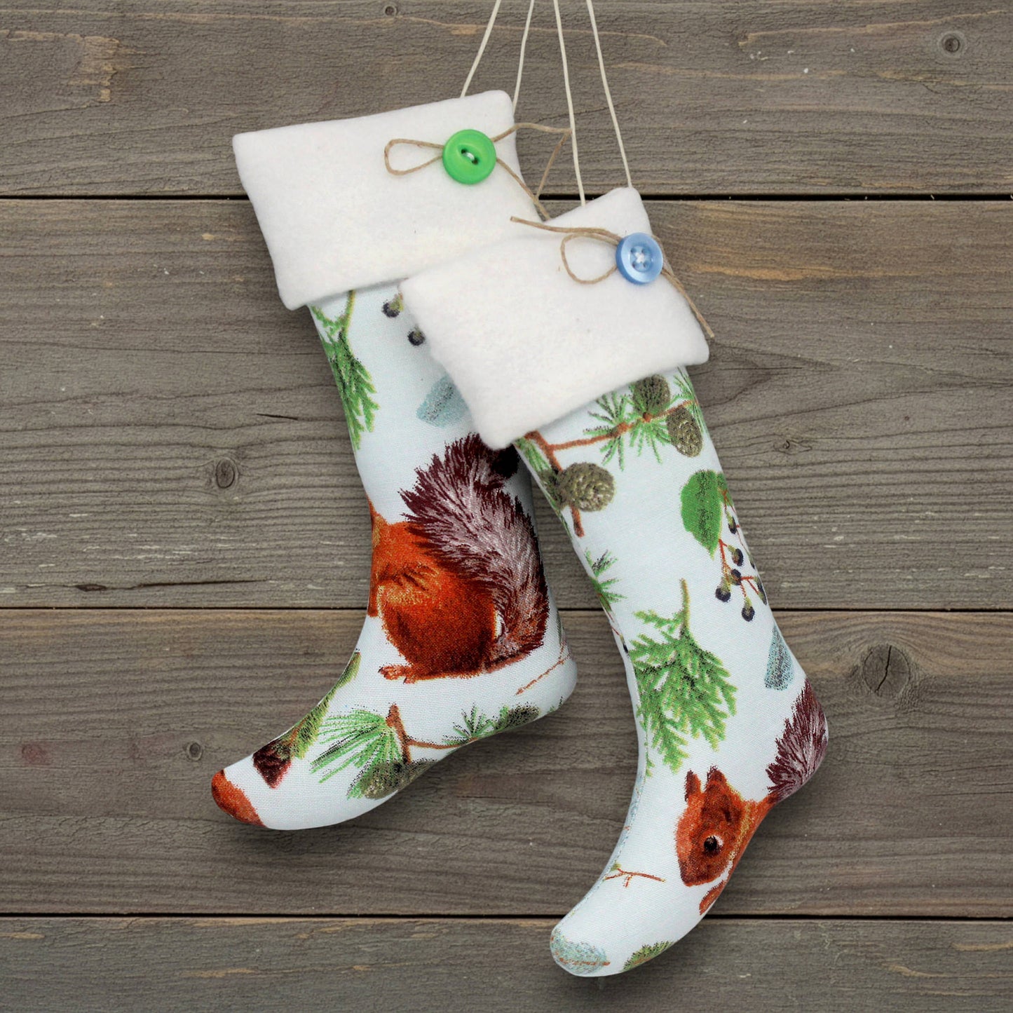 Pair of handmade Christmas stocking ornaments with a print fabric with squirrels and forest greenery