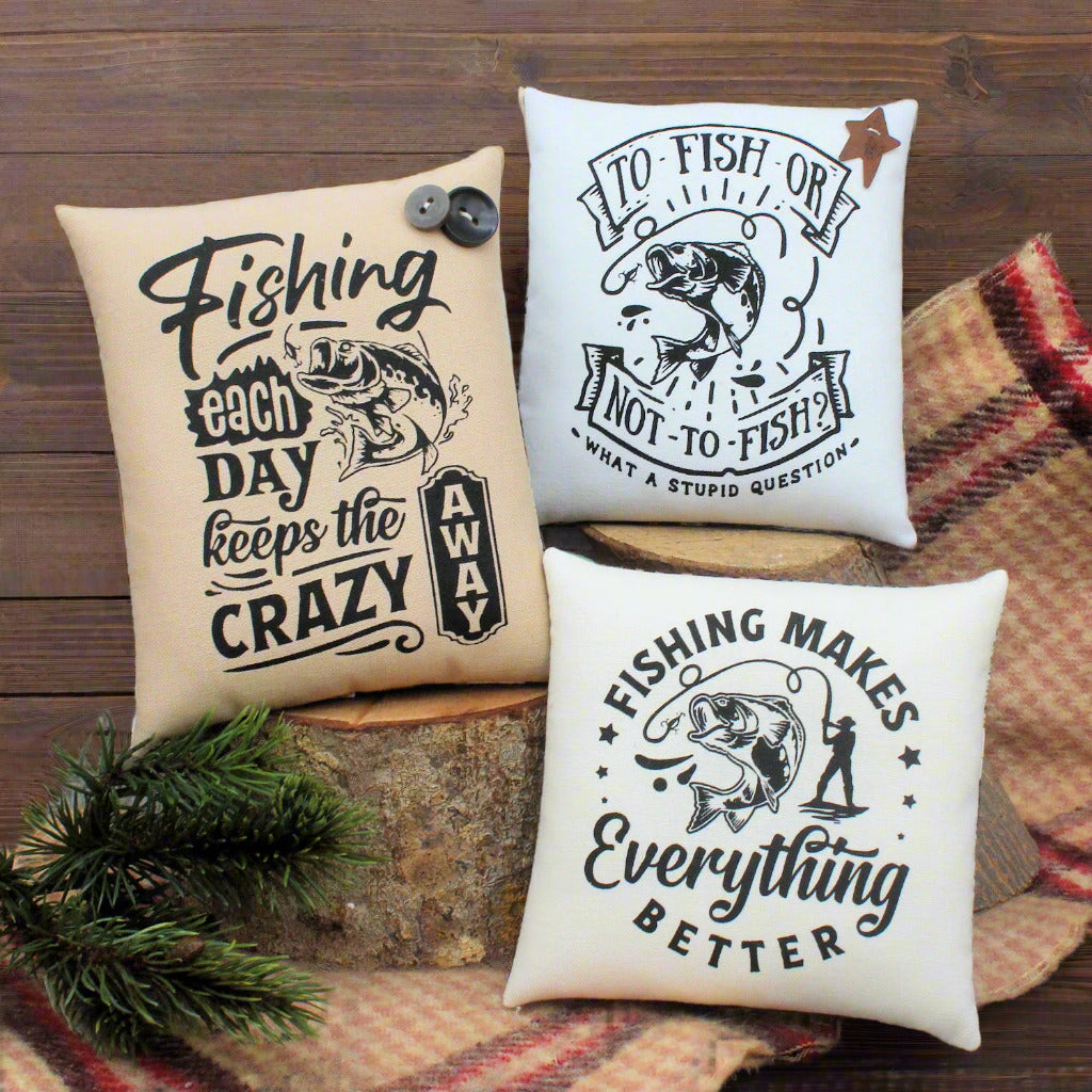 Three fishing-themed pillows on a wooden surface with a rustic background.