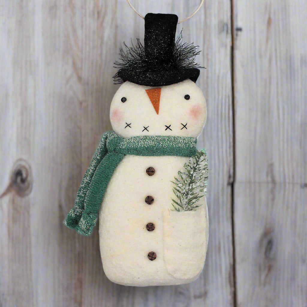 Decorative primitive snowman ornament with a green scarf on a gray background