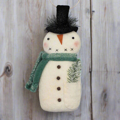 Decorative primitive snowman ornament with a green scarf on a gray background