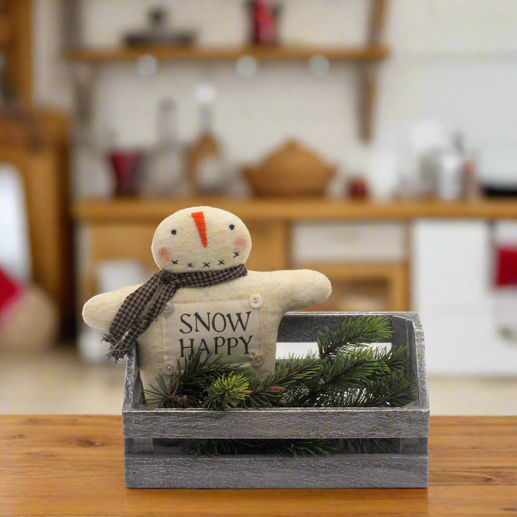 Small snowman figurine with 'Snow Happy' text in a wooden crate