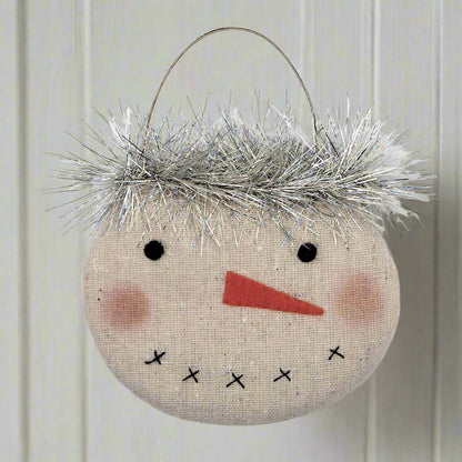 Decorative snowman ornament with tinsel hair on a white background