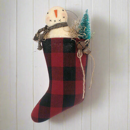Red and black checkered stocking with a snowman decoration on a white background