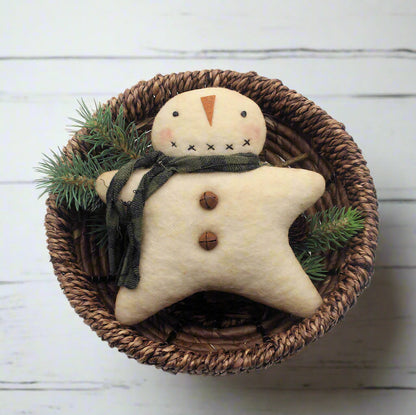 Star-shaped snowman ornament with a green scarf in a woven basket on a white background