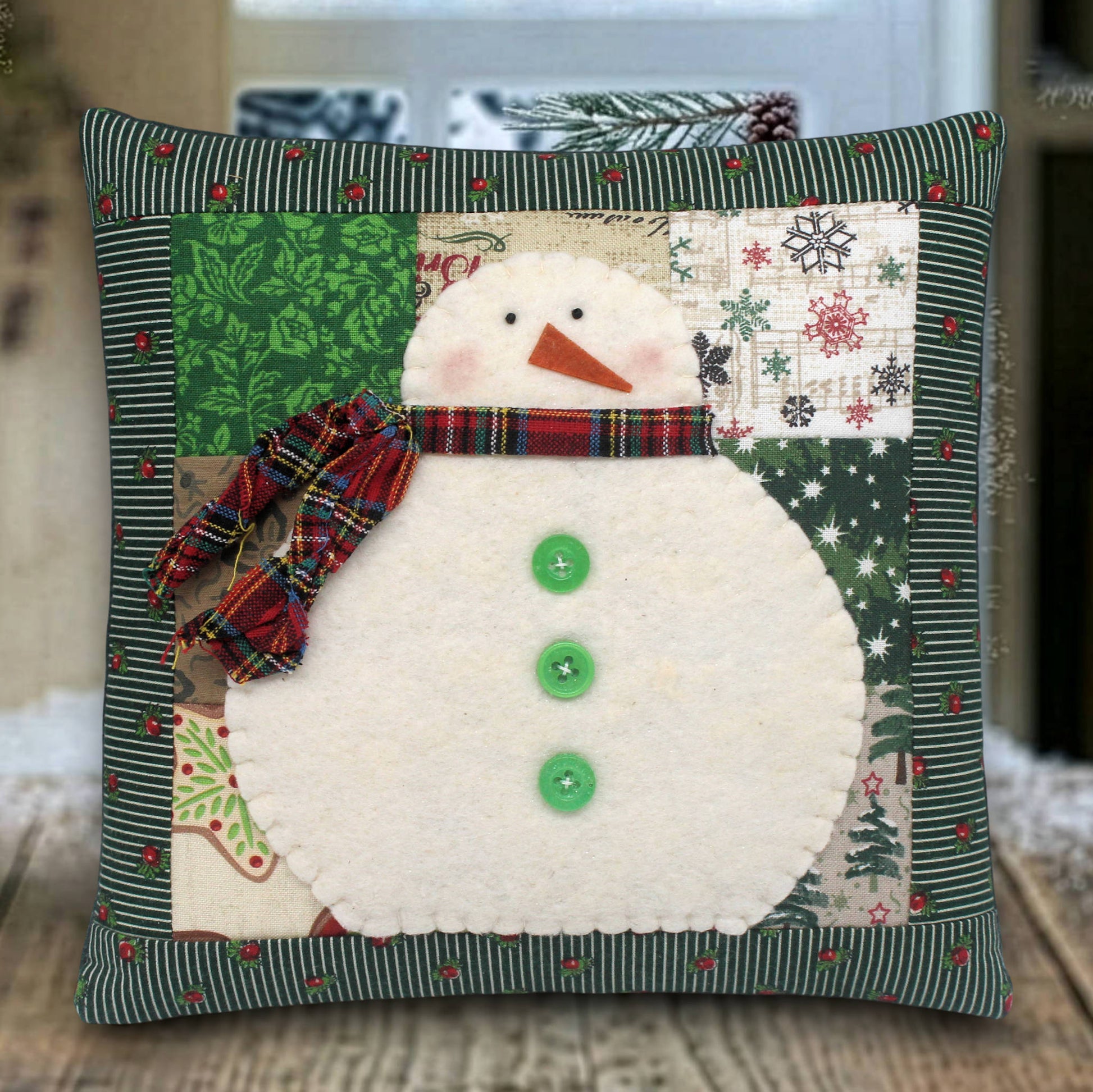 Decorative pillow with a snowman design on a wooden surface