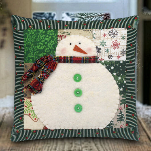 Decorative pillow with a snowman design on a wooden surface