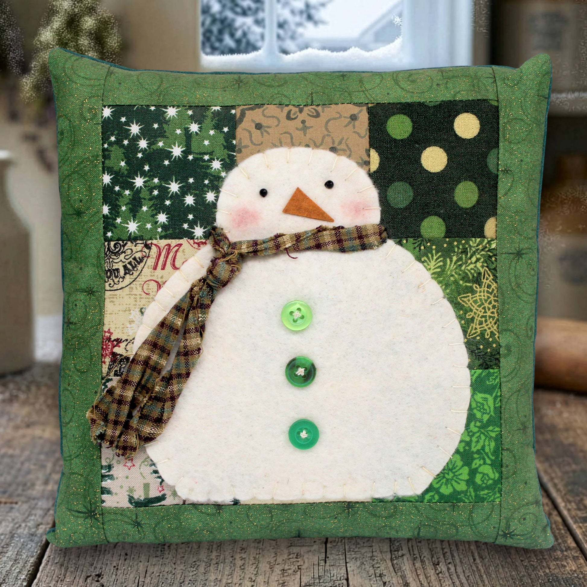 Decorative pillow with a snowman design on a wooden surface