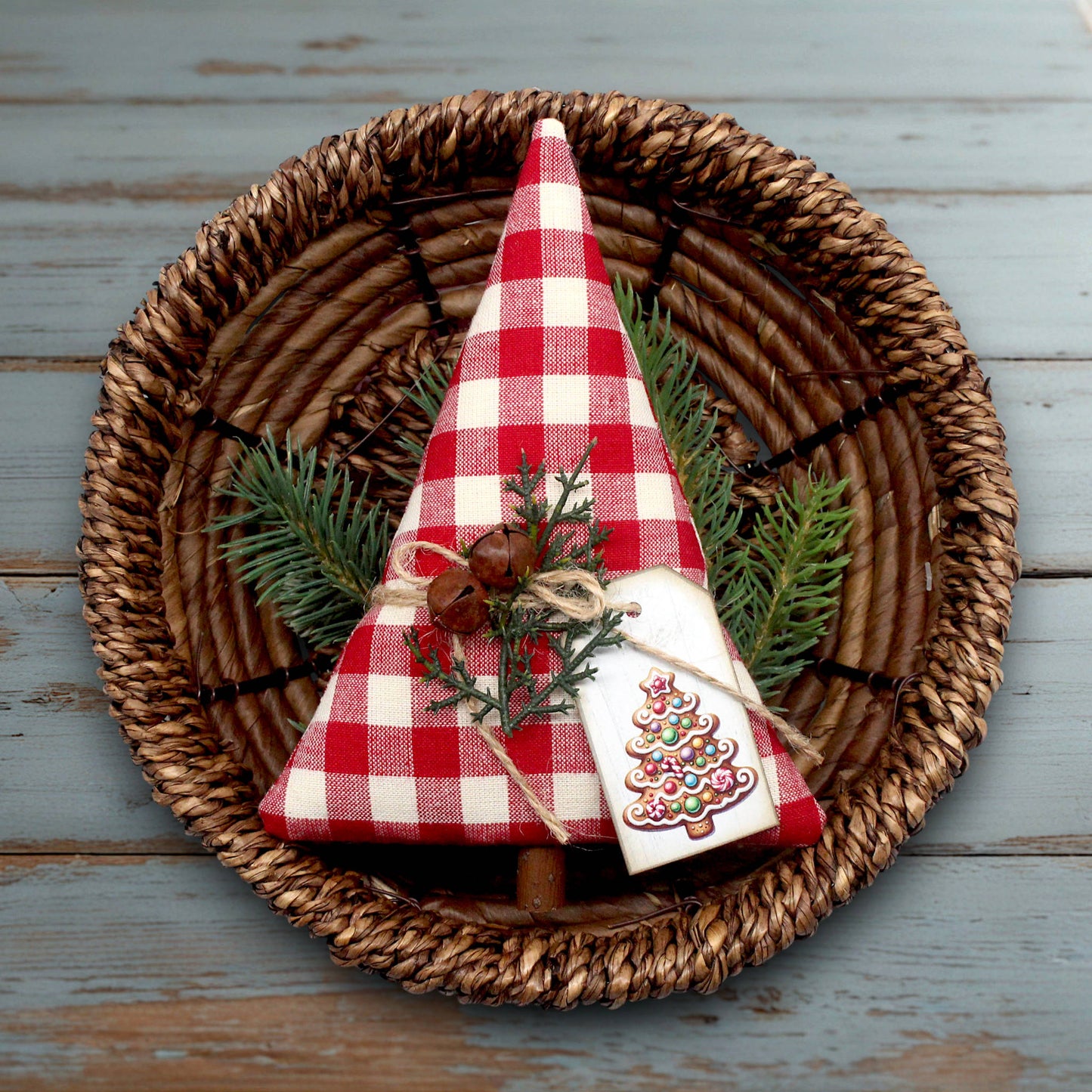 Decorative Christmas tree with red and white checkered fabric on a woven plate.