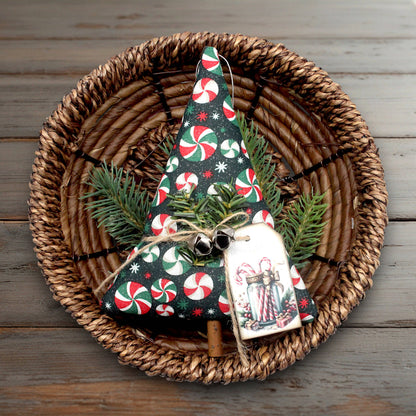 Decorative Christmas tree ornament with candy cane pattern on a woven plate.
