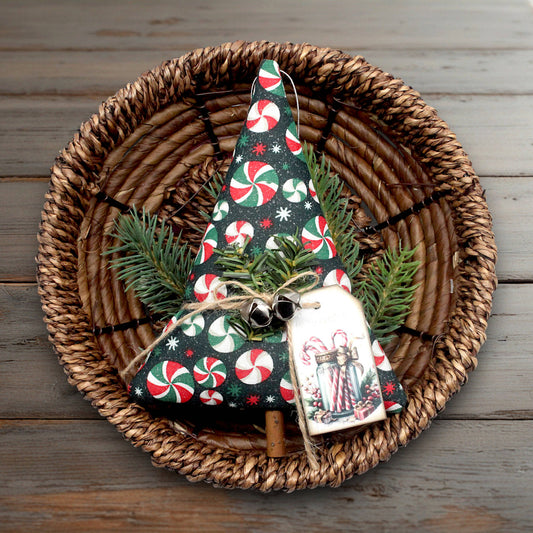 Decorative Christmas tree ornament with candy cane pattern on a woven plate.
