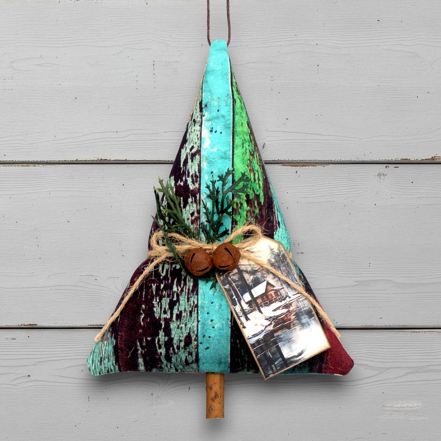Decorative Christmas tree-shaped ornament with natural elements on a green wooden background