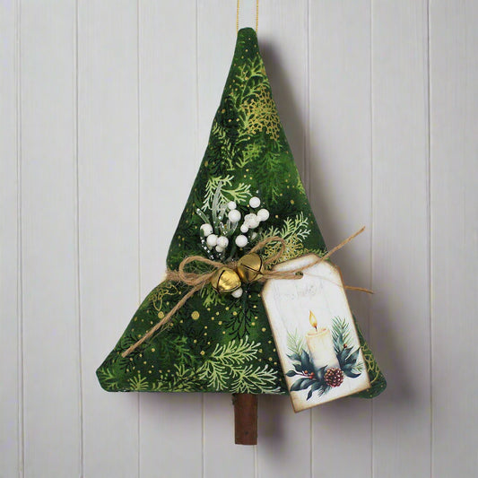 Decorative Christmas tree ornament with green fabric, gold jingle bells, and a small tag on a white background.