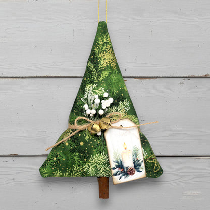 Decorative Christmas tree ornament with green fabric, white berries, and a candle on a wooden surface.