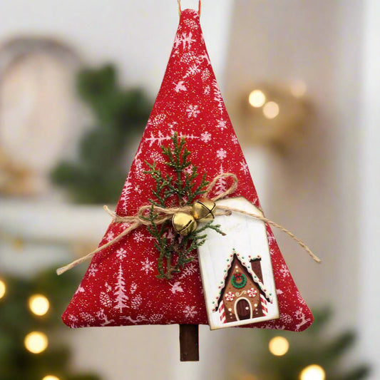 Decorative Christmas tree ornament with red fabric, greenery, and a gingerbread house tag