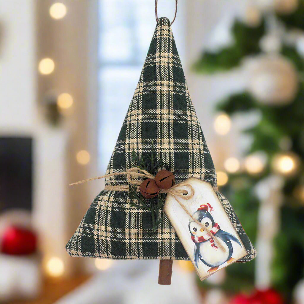 Green homespun Christmas tree ornament or bowl filler with rusty bells, greenery and a penguin tag