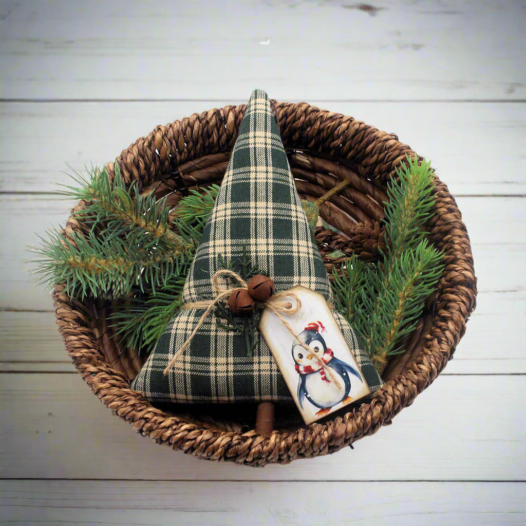 Decorative Christmas tree with plaid pattern in a woven basket with pine branches on a white background