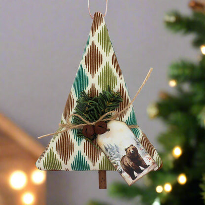 Tree-shaped Christmas ornament or bowl filler sewn from woodsy fabric with rusty bells, greenery and a tag with a grizzly bear