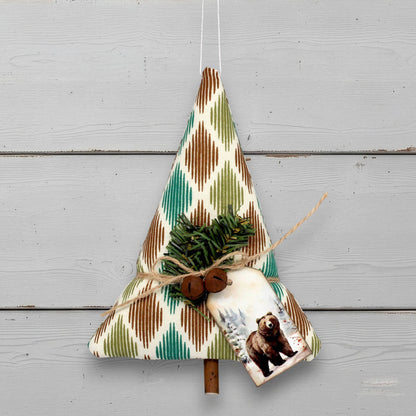 Decorative Christmas tree-shaped ornament with a bear tag design on a wooden background