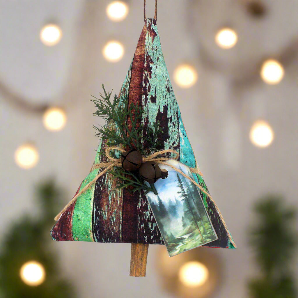 Tree-shaped Christmas ornament or bowl filler with a weathered wood fabric design, rusty bells, greenery and a tag