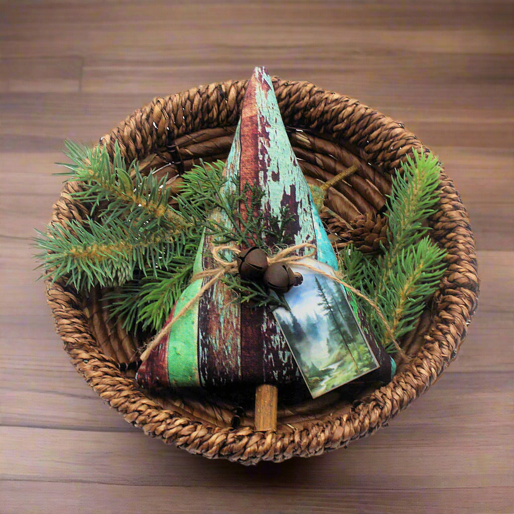 Tree-shaped Christmas ornament or bowl filler with a weathered wood fabric design and rusty bells, greenery and a tag