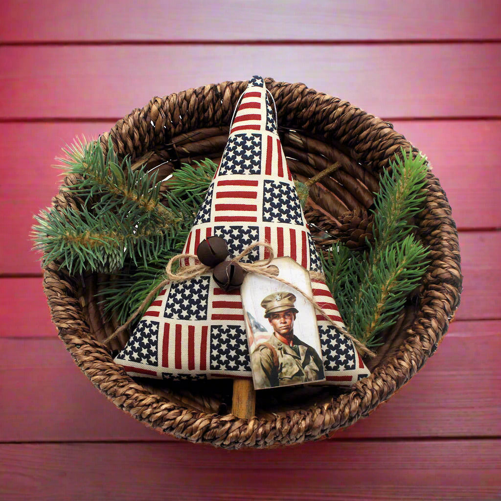 Decorative ornament with American flag design and photo on a woven base with greenery
