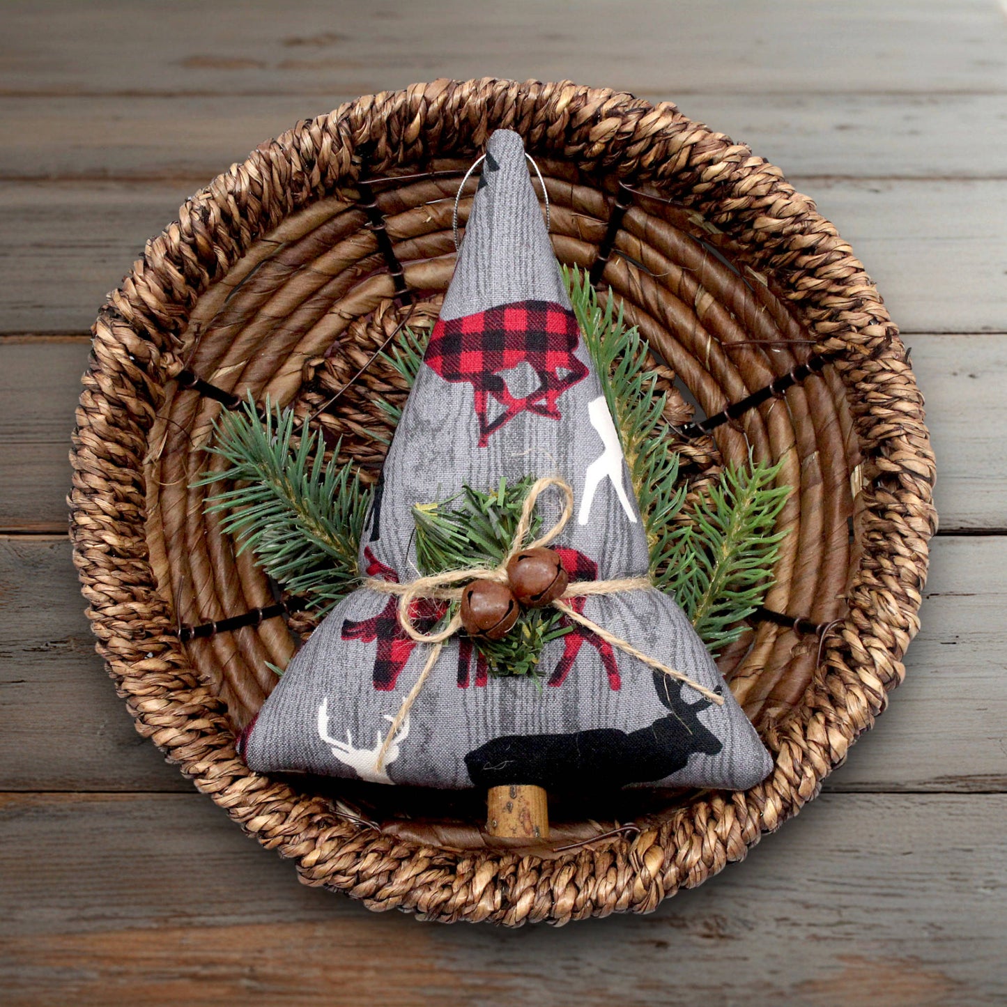 Decorative Christmas tree ornament with plaid accents on a woven plate.