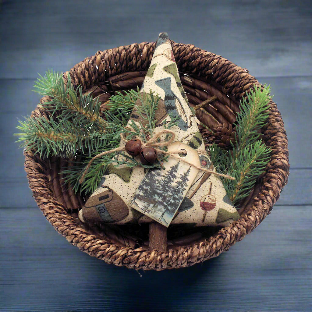 Decorative item with a fabric triangle and greenery in a woven basket
