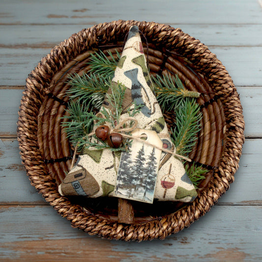 Decorative item with tree design and greenery in a woven basket on a wooden surface