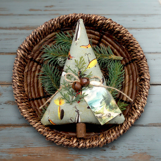 Decorative Christmas tree ornament with nature-themed fabric on a woven plate.