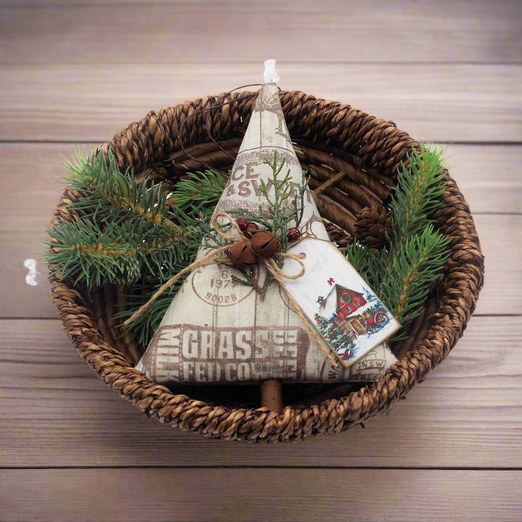 Decorative Christmas tree ornament with text and pine branches in a woven basket