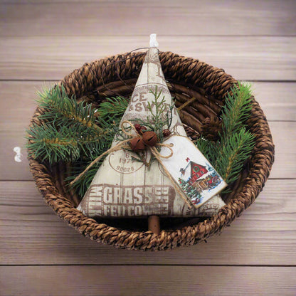 Decorative Christmas tree ornament with text and pine branches in a woven basket
