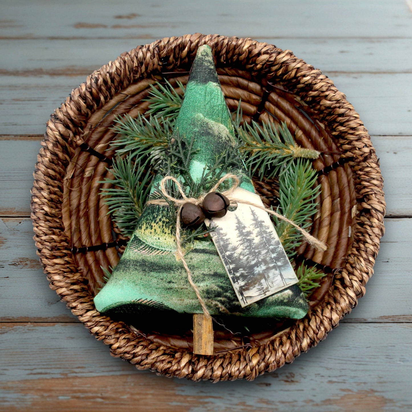 Decorative green tree ornament with a tag on a woven plate