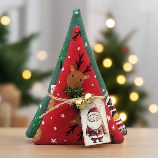 Decorative Christmas tree-shaped ornament with reindeer and Santa Claus on a blurred festive background.