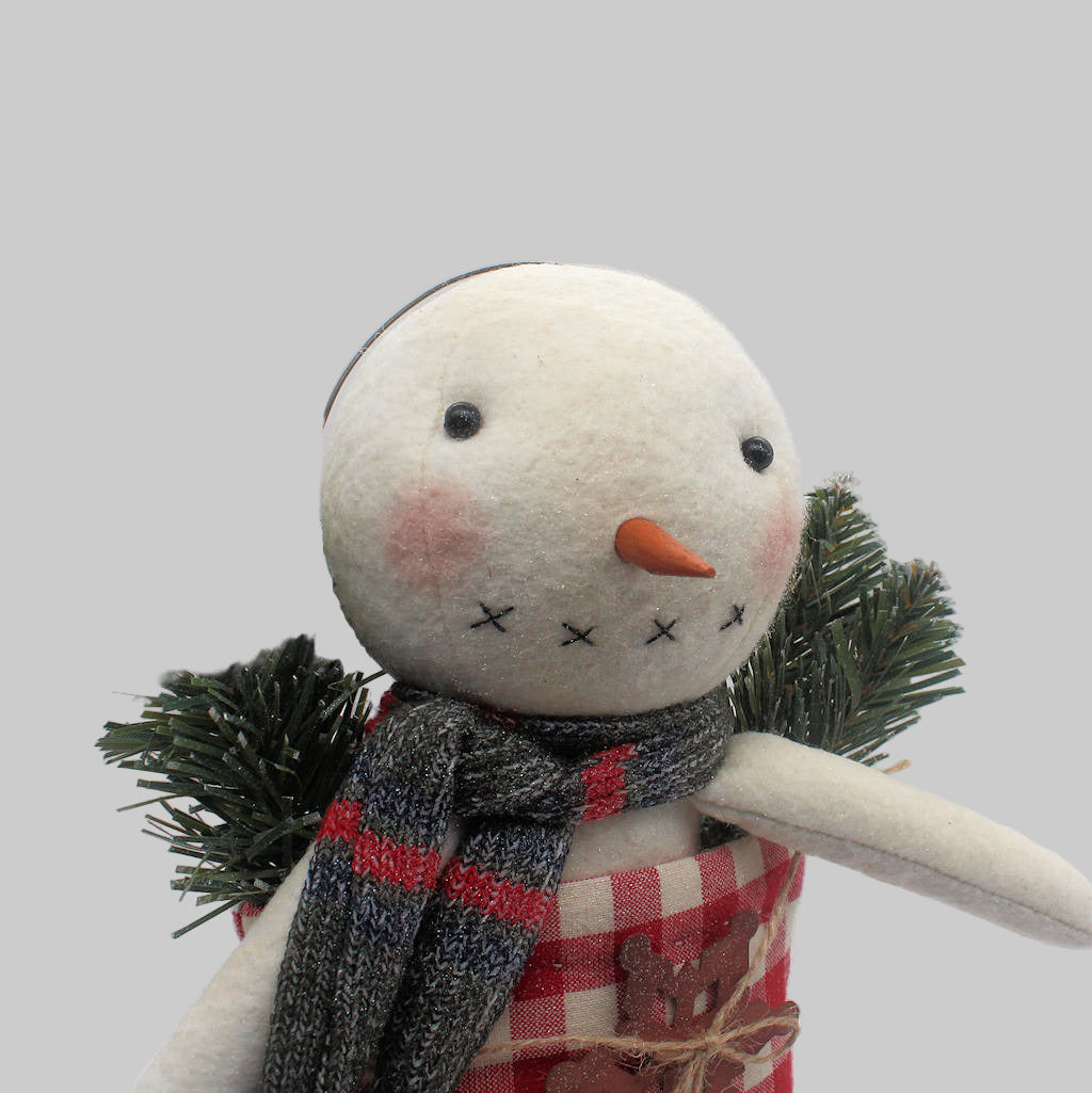 Primitive snowman in a red and white homespun stocking along with pine and a rusty snowflake