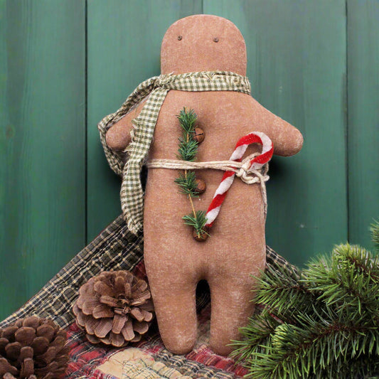 primitive gingerbread man doll with a candy cane tucked into his waistband