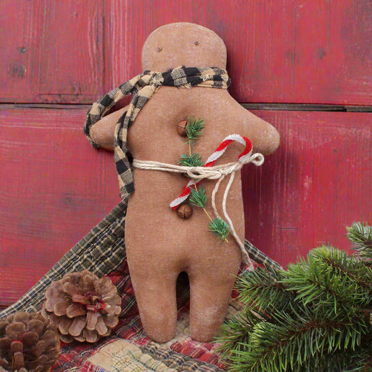 primitive gingerbread doll with a candy cane tucked into his waistband