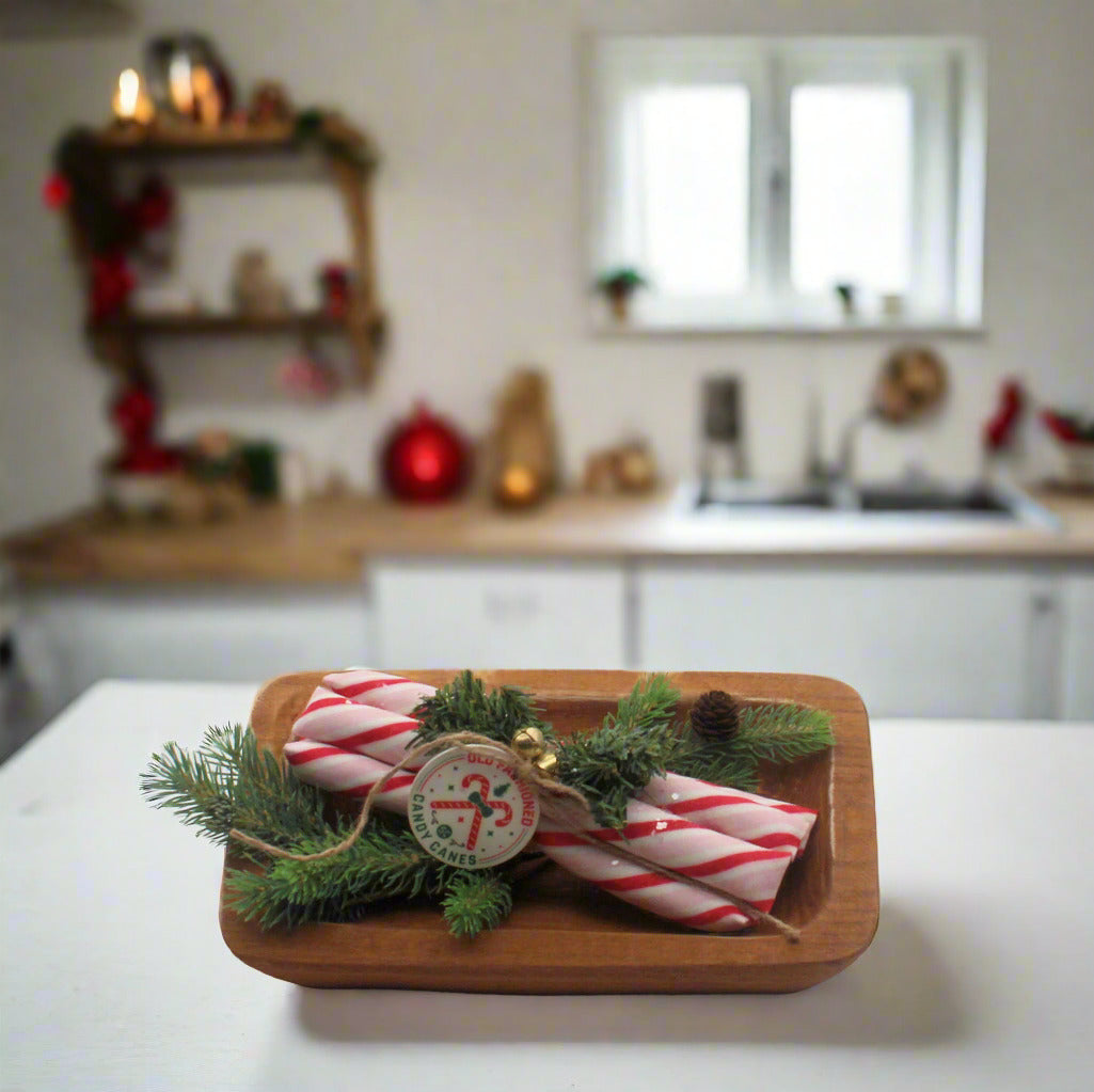 Wooden box with Christmas decorations including candy canes and pine in a country kitchen