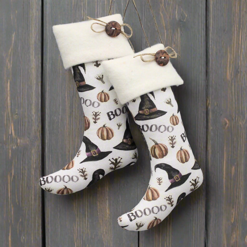 Halloween-themed stocking with pumpkins and witch hats on a gray background