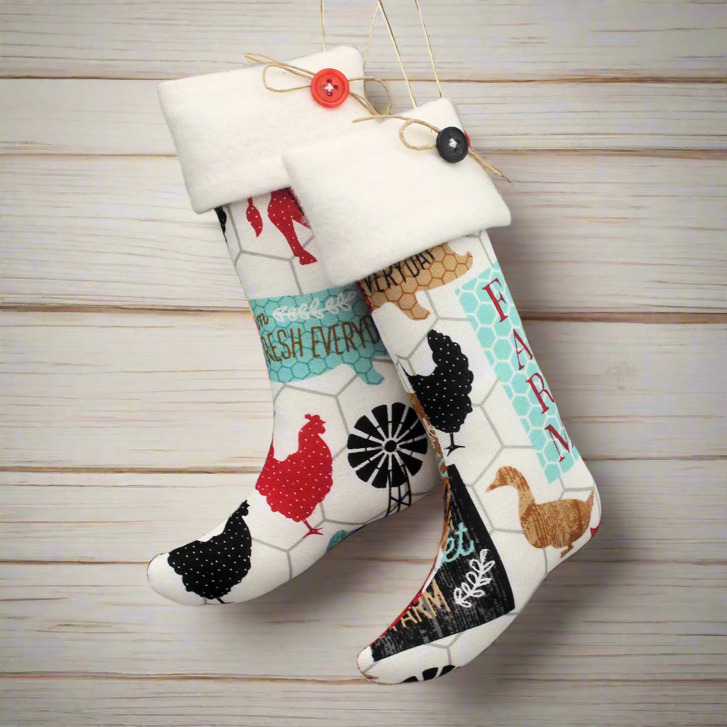 Christmas stocking ornaments with colorful farm animals on a white background with white cuffs decorated with buttons
