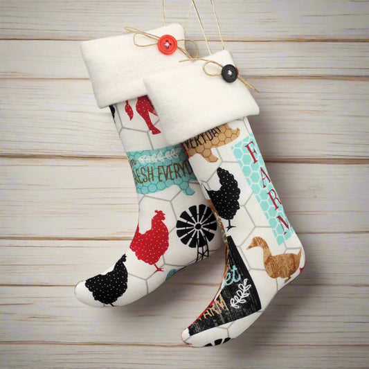 Christmas stocking ornaments with colorful farm animals on a white background with white cuffs decorated with buttons