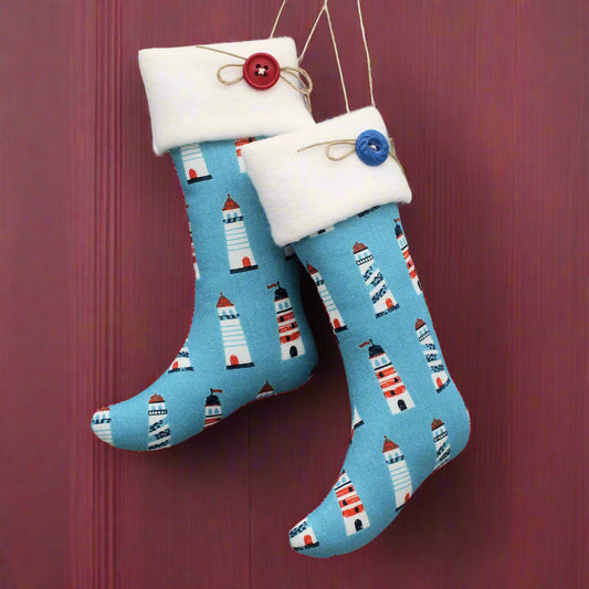 Blue stockings with lighthouse pattern hanging on a red door